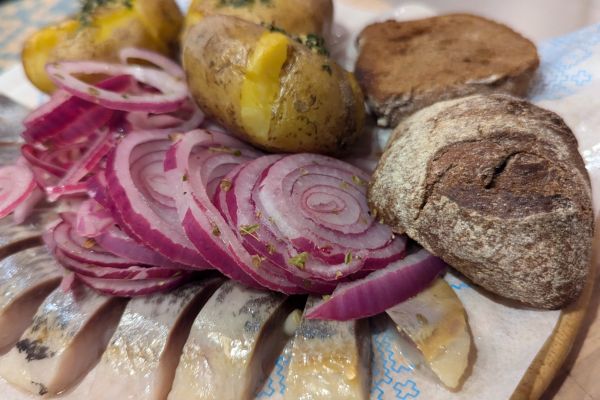 Salted herring with boiled potatoes and onions on a plate