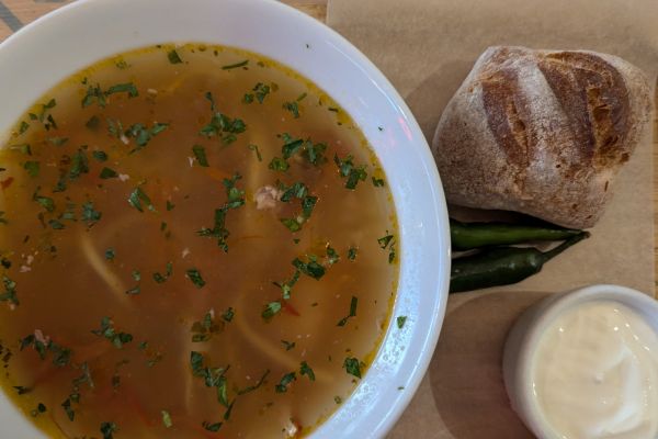 Bowl of Moldovan zeamă chicken soup with noodles and parsley