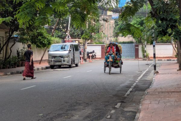 Rickshaw puller and man walking in quiet streets in Banani Dhaka
