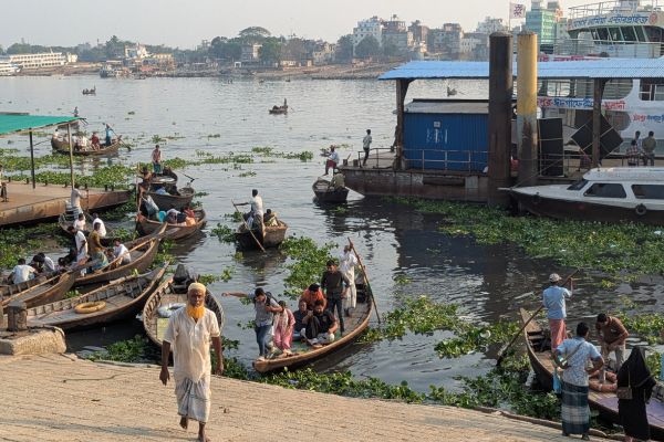 Ferryman walks up steps in front of ferries and launches at Sadarghat in Dhaka