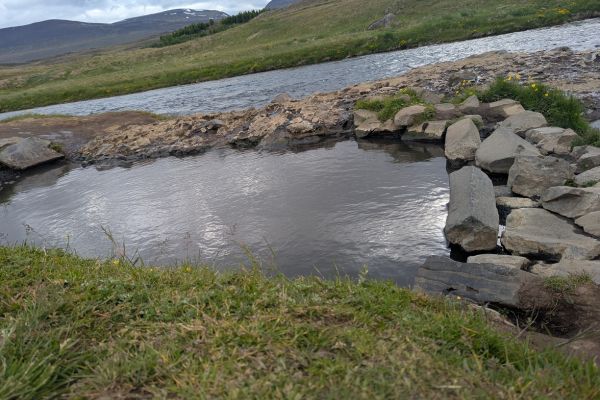 The hot spring pool of Fosslaug right by the very cold river