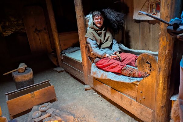 Guide at Eirikstadir inside the rebulit turf house